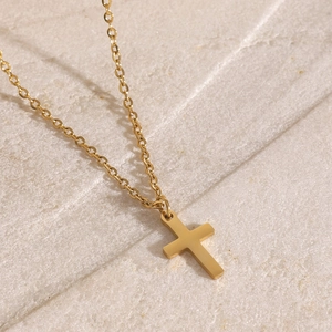 Minimalist triple-layer gold stainless steel cross pendant necklace on stone background