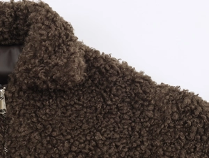 Detail of coffee brown faux fur jacket with lapel collar and metal zipper closure