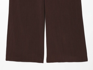 Gros plan du bas d'un pantalon marron à fines rayures montrant l'ourlet et le tissu