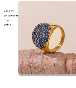 Detail of wide gold-plated ring with micro-paved blue zircons on a textured stone