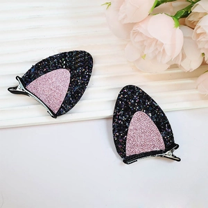 Detail showing black and pink glitter cat ear hair clips with metal alligator base