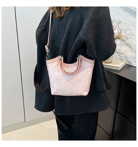 Detail of light pink floral embroidery handbag with leather strap and silver hardware