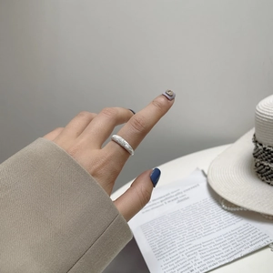 Close-up of sparkling textured silver ring on hand with minimalist aesthetic background
