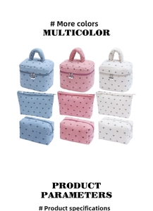 Three corduroy cosmetic bags with black heart prints in blue, pink, and off-white colors