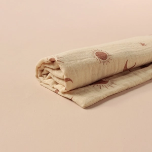 Vue détaillée du tissu en mousseline de coton froissé avec motifs soleil et lune
