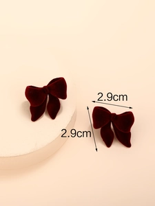 Detailweergave van de donkerrode fluwelen strik oorbellen met afmetingen 2,9cm