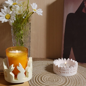 Detail of bunny and city silhouette plaster candle holders with flickering warm light