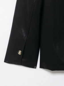 Detailed close-up of a buttoned cuff on a premium black coated leather jacket