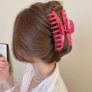 Glossy red square silicone hair claw clip securing a high bun on female model