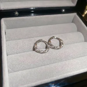 Silver twisted rope hoop earrings with sparkling cubic zirconia in minimalist style