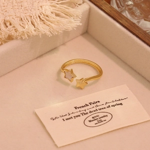 Golden double star open ring with white mother-of-pearl inlay in a jewelry box