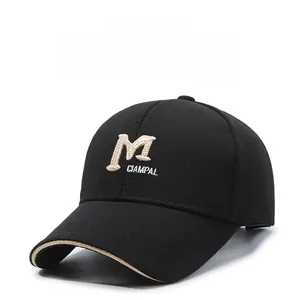 Detailed embroidery of letter M on black cotton baseball cap with beige brim edging