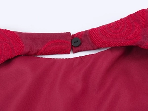 Détail du tissu jacquard rouge avec ouverture au dos et fermeture par bouton noir