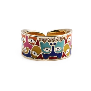 Détail d'une bague en cuivre avec motif de visage en émail coloré et strass