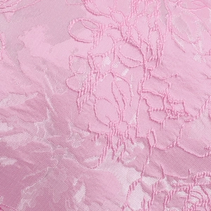Close-up detail of pink floral jacquard fabric with elegant silk-like texture and 3D patterns