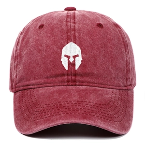 Close-up of white spartan helmet embroidery on washed burgundy cotton baseball cap