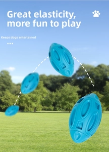 Blue rubber squeaky rugby dog toy bouncing on grass showing high elasticity and durable texture