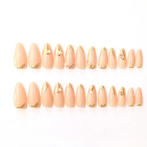 Nude almond press-on nails with 3D gold accents, pearls and rhinestones on white base