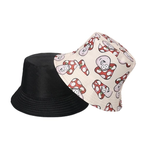 Close-up of reversible bucket hat detail showing black side and mushroom print cotton fabric