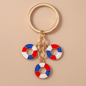 Detailed view of nautical lifebuoy charms on a gold metal keychain with blue and red enamel