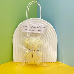 Detail of yellow pineapple grid coral fleece towel folded into a bear gift bag