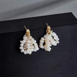 Detail view of woven freshwater pearl earrings with 14k gold plated triangular design