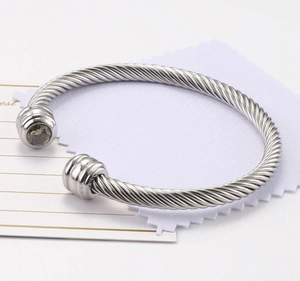 Detail of silver twisted wire cuff bracelet featuring a gray zircon inset on the end cap