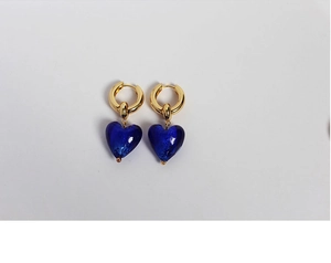 Detailed view of the vintage Murano glass blue heart pendant on golden hoop earrings