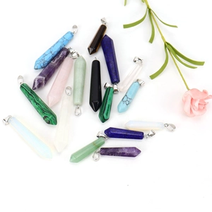 Natural hexagonal crystal prism pendants set with silver metal bails on white background