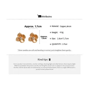 Macro shot of gold-plated flower earrings with cubic zirconia and size specifications