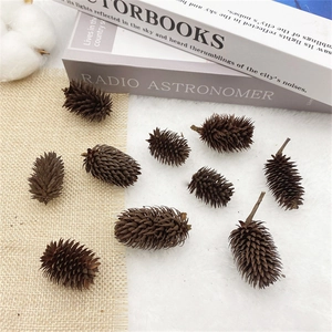 Macro detail of natural brown pine cones on a soft white fur and rustic burlap background