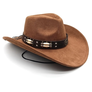 Détail d'un chapeau de cow-boy en suède avec bande en cuir, perles et emblème en métal