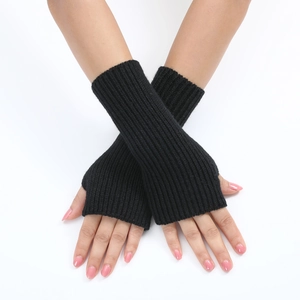 Close-up of black knitted fingerless gloves with striped texture on model hands