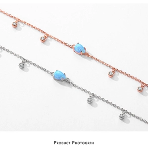 Détail de bracelets en or rose et argent avec opale bleue en goutte et zircons brillants