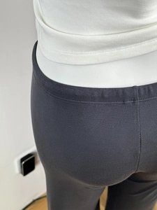 Close-up of black ribbed wide-leg trousers with lightweight drape and elastic waistband