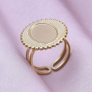 Detail of gold oval signet ring with beaded edge on purple silk background