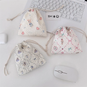 Three seersucker drawstring pouches with cute rabbit patterns on a white desk