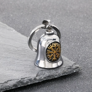 Détail macro du porte-clés boussole viking avec clochette sur fond de pierre grise