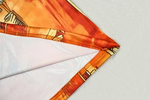 Macro shot of stitching detail and orange-yellow art print on this vintage bodycon dress