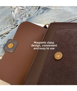 Detailed close-up of the vintage brown shoulder bag showing its gold magnetic buckle