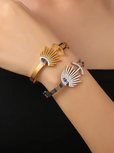 Detail of 18K gold and silver evil eye spring bracelets with blue enamel and crystals