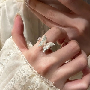 Close-up of adjustable silver ring featuring a pearlescent butterfly and mini zircon detail