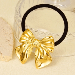 Elegant 304 stainless steel gold bow hair tie on a minimalist textured surface