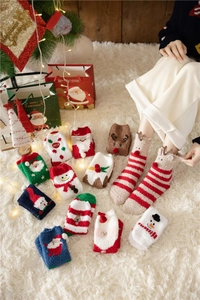 Close-up of thick coral fleece Christmas socks with festive patterns on a plush rug