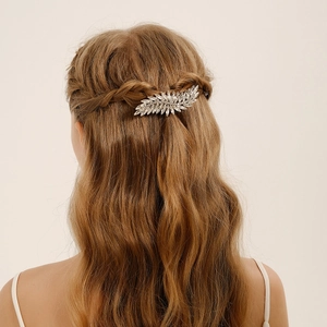 Elegant silver leaf hair clip with rhinestones on a model's long brown hair