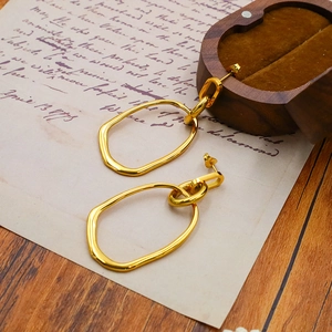 Minimalist gold irregular geometric oval earrings in a vintage aesthetic setting