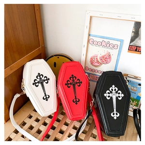 Detail of gothic coffin cross bags in white, red, and black on a wooden bench