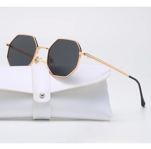 Octagonal metal sunglasses with grey lenses next to a white leather protective pouch