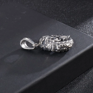 Close-up of a punk-style stainless steel skull pendant with a polished silver finish