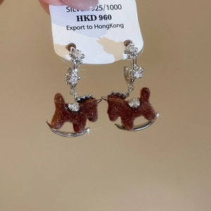 Detailed close-up of brown flocked rocking horse earrings with 925 silver flower studs